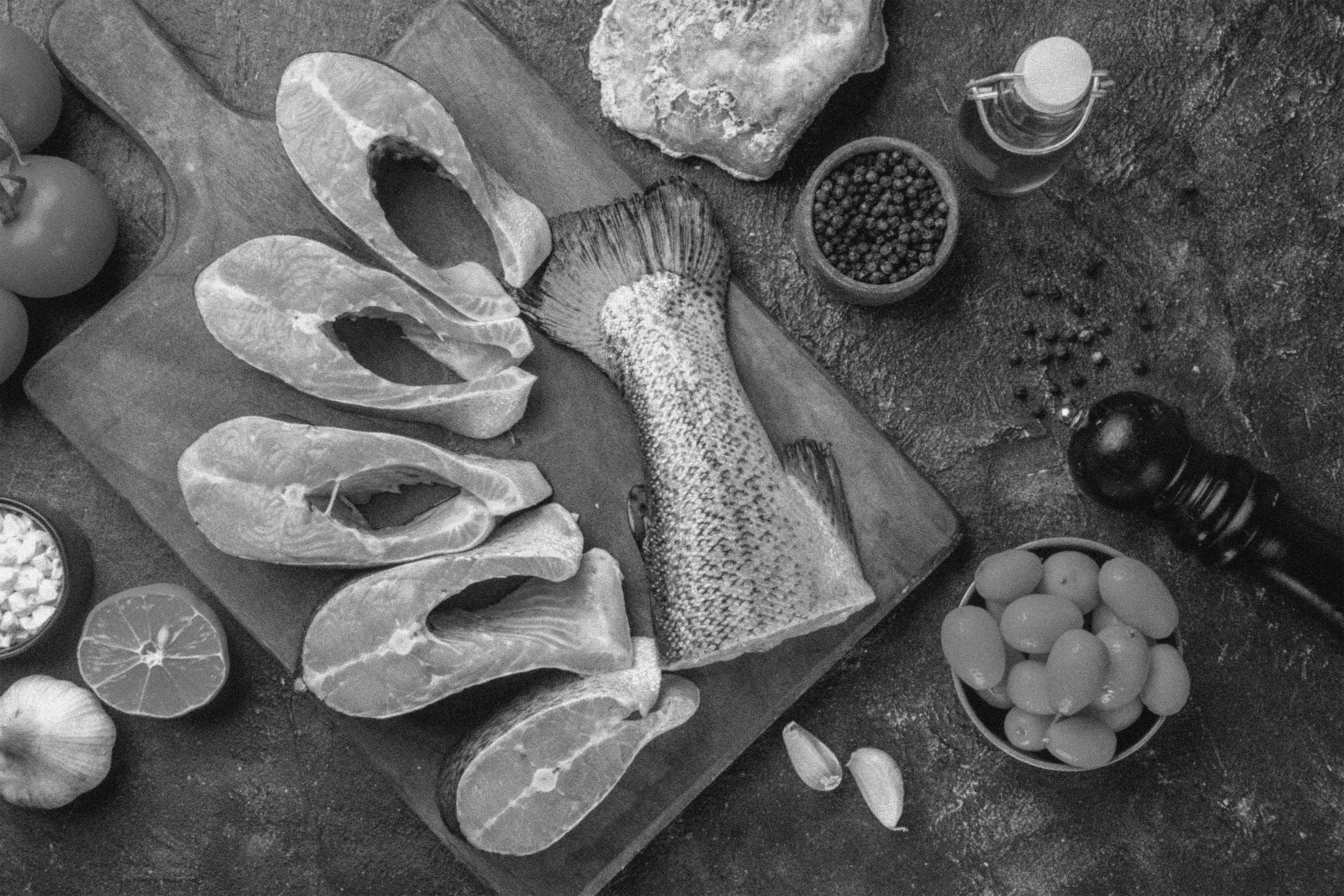 1top-view-fresh-raw-fishes-wooden-cutting-board-spices-oil-bottle-lemon-kumquats-garlic-dark-mix-colors-table.jpg